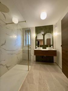 a bathroom with a shower and two sinks and a mirror at T4 moderne parking Théodore Bac - DABNB in Limoges