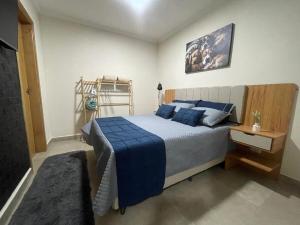 a bedroom with a large bed with blue pillows at Apartamento 01 quarto in Três Lagoas