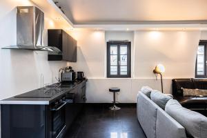 a kitchen with a counter and a couch in a room at La Parenthèse- Place Martroi- Vue- Clim réversible in Orléans