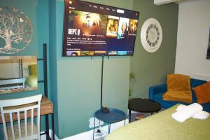 Zimmer mit einem Bett und einem TV an der Wand in der Unterkunft 3-Bedroom House Close to City Centre and M5 with Garden and Parking in Bristol