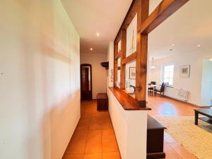 a hallway of a home with white walls and orange tile floors at Kranichhaus Boddenblick in Saal +20 photos
