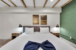 Un dormitorio con una cama blanca con una corbata azul de moño. en Nola Retreat Next To Frenchmen & French Quarter, en Nueva Orleans