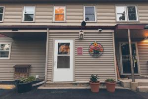 a house with a white door and flowers in pots at Retreat to Bass Creek 2 BR Apartment A Your Escape in Janesville