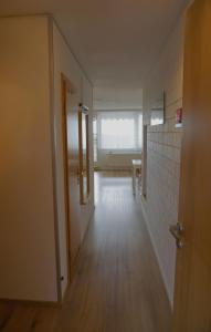 an empty hallway with a door to a room with a table at Sylva Apartment inkl TG-Platz im Predigtstuhl Resort in Sankt Englmar +16 photos