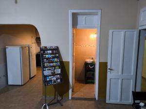 a room with a refrigerator and a shelf with pictures at Parvis Magna HOSTAL in Barraquero