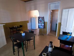 a restaurant with tables and chairs and a refrigerator at Parvis Magna HOSTAL in Barraquero