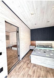 a bedroom with a large bed and a wooden floor at Inn Alibi in Khorodelets