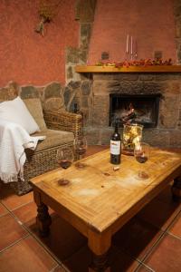 a table with wine glasses and a fireplace at Casa Rural La Milagrosa in San Martín de Moncayo