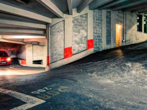 an empty parking garage with a car parked in it at Mercure Lyon Centre Saxe Lafayette in Lyon