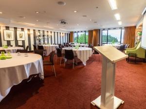 クイーンズタウンにあるHotel St Moritz, Queenstown - MGallery Collectionの白いテーブルと椅子と窓のあるダイニングルーム