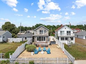 a house with a white fence and blue chairs at Luxury Waterfront Home Perfect for Family in Fall River +60 photos