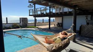 皮奇勒姆Sudeste Hostel的躺在游泳池旁吊床上的男人