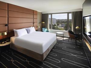 een hotelkamer met een bed en een groot raam bij Mercure Sydney Parramatta in Sydney +77 foto's