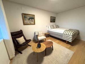a bedroom with a bed and a chair and a table at Appartment with garden and a big bathroom in Malvik