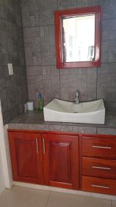 une salle de bain avec un lavabo et un miroir dans l'établissement Villa Agustina en Villas Camino Real cerca de las dunas de Chachalacas, à Ursulo Galván 49 autres photos