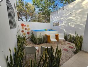 a backyard with a hot tub and chairs at Alberca-Privacidad-Confort in Mérida