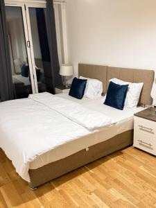 a large bed with blue pillows in a bedroom at Lovely home in Finchley +11 photos