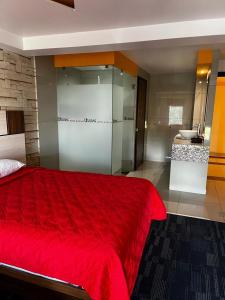 een slaapkamer met een rood bed en een badkamer bij Hotel Urbane in Mexico-Stad