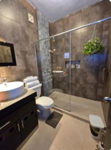 a bathroom with a shower and a toilet and a sink at Alberca-Privacidad-Confort in Mérida