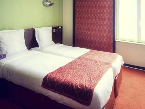 a hotel room with two beds and a window at Mercure Strasbourg Centre Gare in Strasbourg