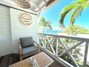 a chair on a balcony with a view of the ocean at La p’tite barque Antillaise in Deshaies
