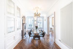 a dining room with a table and chairs and a chandelier at Gîte Vosges en Ville luxueux appartement Duplex avec sauna espace bien être au centre d'Epinal in Épinal