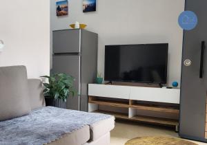 uma sala de estar com televisão num centro de entretenimento branco em Flor Apartment em Pogradec