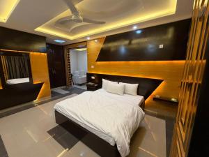 Un dormitorio con una cama grande con cabecero de madera. en the best stay hotel in peshawar, en Peshawar