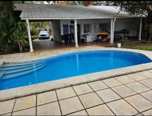 a blue swimming pool in front of a house at Casa al rio con muelle privado Paso de la Patria in Paso de la Patria +12 photos