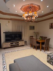 ein Wohnzimmer mit einem großen TV und einem Tisch in der Unterkunft Luna Luxury Apartment in Medina
