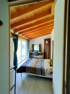 a bedroom with a large bed with a wooden ceiling at Réveil au chant des Oiseaux in Chalain-le-Comtal