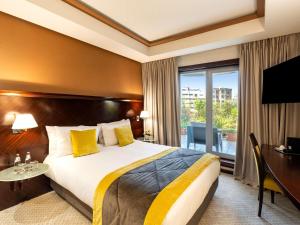 a hotel room with a bed and a desk and a window at Le Diwan Hotel Rabat - MGallery Collection in Rabat +139 photos