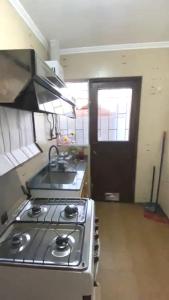 a kitchen with a stove and a sink and a door at Vacation rental house La Serena Chile in La Serena