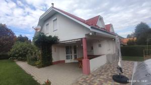 een wit huis met een rood dak bij Magyar Tenger Pihenőház, 4-8 főre Balatonakarattya in Balatonakarattya