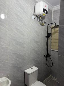a bathroom with a white toilet and a shower at 9th House Apartments in Lagos