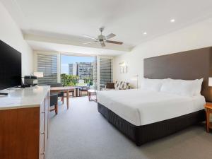 a hotel room with a large bed and a desk at Pullman Reef Hotel Casino in Cairns