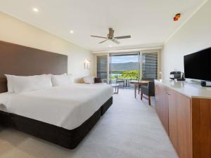 a bedroom with a large bed and a television at Pullman Reef Hotel Casino in Cairns