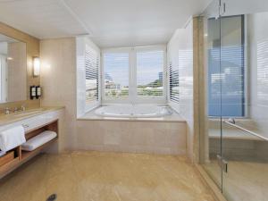 ケアンズにあるプルマン リーフ ホテル カジノのバスルーム(バスタブ、シャワー付)、窓が備わります。 +75枚の写真