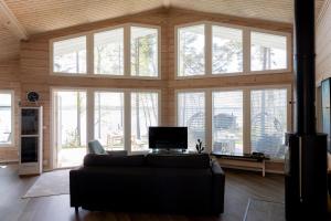 a living room with a couch and a large group of windows at Töyräniemi in Pälkäne