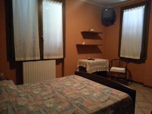 a bedroom with a bed and a table and two windows at Lo Zodiaco in Roncobillaccio