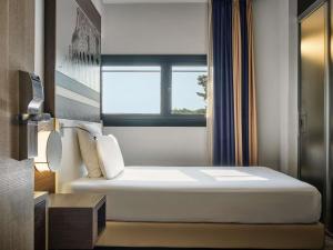 ein Hotelzimmer mit einem Bett und einem Fenster in der Unterkunft Mercure Roma Centro Colosseo in Rom