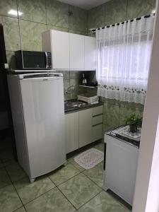 a kitchen with a refrigerator and a microwave at Casa Amora - 2 Quartos in Pomerode +16 photos