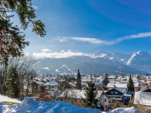 a snow covered city with mountains in the background at Mercure Hotel Garmisch Partenkirchen in Garmisch-Partenkirchen +71 photos