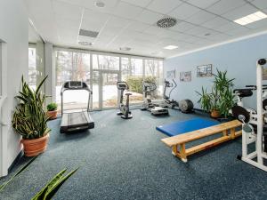 a gym with treadmills and exercise equipment and plants at Sunday Hotel Garmisch Partenkirchen in Garmisch-Partenkirchen