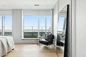 トロントにあるRare One of a Kind Sub-Penthouse Parkingのベッドルーム(鏡、椅子、ベッド付)