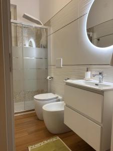 Un baño blanco con inodoro y lavabo. en Gioia Apartment, en Sabaudia