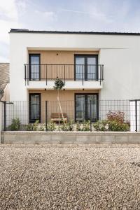 a white house with a fence in front of it at Dream Premium Apartman in Mosonmagyaróvár
