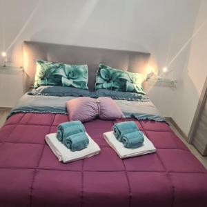 1 cama grande con 2 almohadas y toallas. en Il Campanile, en Santa Maria del Molise