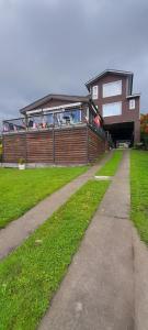 a house with a pathway in front of a house at Hostal lago Ranco Boutique in Lago Ranco +3 photos