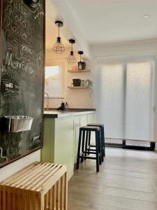 a kitchen with a counter and a bar with a stool at Casa Nidos in Santiago